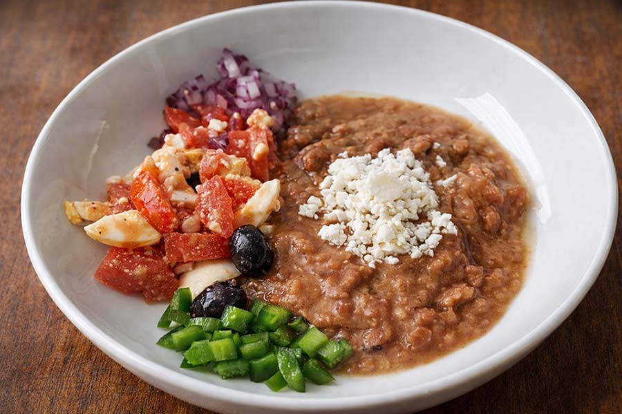 Traditional Eritrean and Ethiopian full breakfast fuul served with tomatoes, onions, peppers and cheese at Red Sea Restaurant in Oakland Park Florida